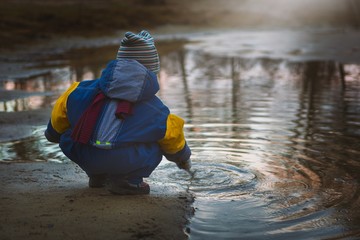 Little boy playing on lake shore