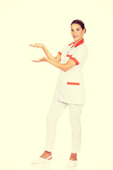 Smiling female doctor or nurse pointing at something