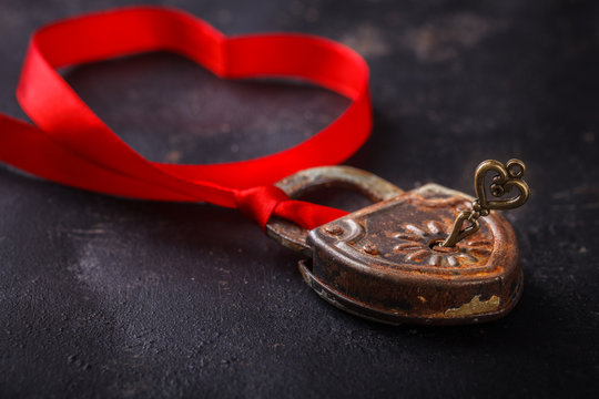 Padlock with key and a red ribbon ,the symbol of love.The background to the Valentine's day.selective focus.