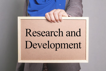 Businesswoman holding a softboard written Research and Development
