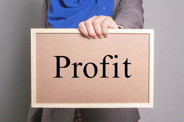 Businesswoman holding a softboard written Profit
