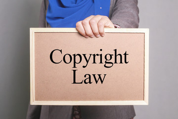 Businesswoman holding a softboard written Copyright Law