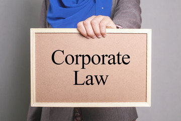 Businesswoman holding a softboard written Corporate Law