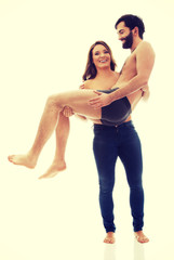 Young woman carrying man on her arms.