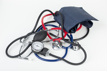 Sphygmomanometer and stethoscopes laying on a white medical work