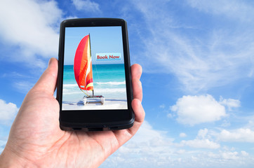 Hand holding a black mobile phone with an online booking applica
