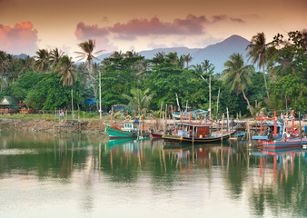 Thai fishing boats in the harbor at sunset