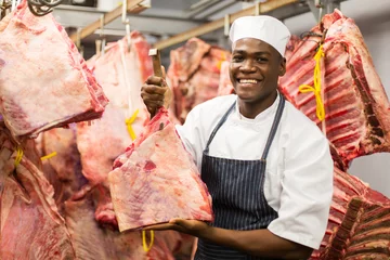 Fotobehang african butcher handing beef in slaughterhouse © michaeljung