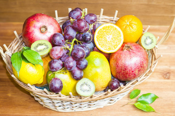 Mieszanka owoców egzotycznych w wiklinowym koszu na drewnianym tle