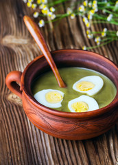 green soup-cream with egg in pottery