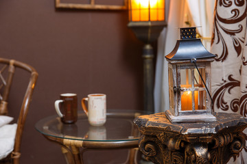 Fototapeta na wymiar Winter scene. Living room, mugs, candle on the table.