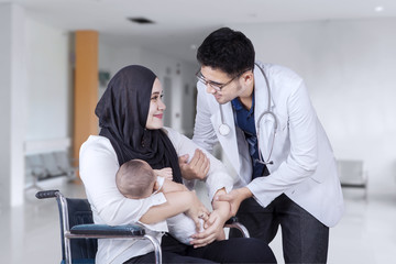 Mother helped by doctor in hospital lobby