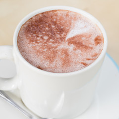 Hot chocolate in a white cup on table