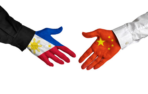 Philippines and China leaders shaking hands on a deal agreement