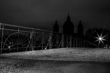 Kabelsteg über die Isar bei Nacht - im Hintergrund St. Lukas (schwarzweiß)