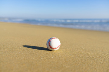 Baseball at a California beach with white wave in pacific ocean