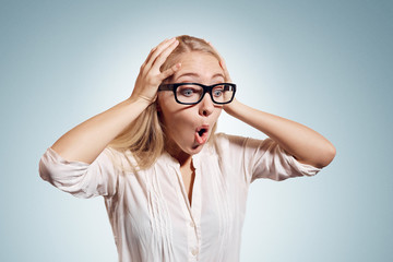 Surprise astonished woman. Closeup portrait woman looking surprised in full disbelief  wide open mouth isolated wall background. Casual young woman looking down. Facial expression body language.