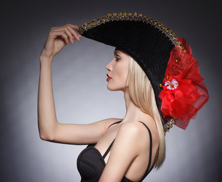 Luxury blonde young woman in a stylish black hat . Beauty portrait.