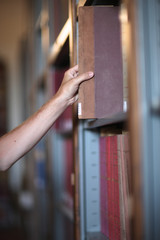 Being a reader, hand of a man choosing a book