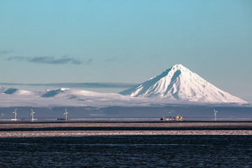 Volcano on the Kamchatka Peninsula, and wind power plants on the sea shore
