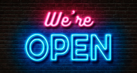 Neon sign on a brick wall - We are open