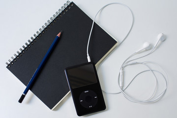 Desk with notebook, pencil and ipod
