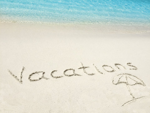 Inscription " Vacations" in the sand on a tropical island,  Mald