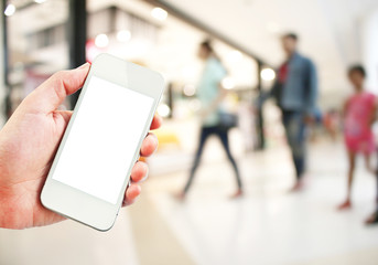 Female hand holding mobile smart phone on Supermarket blur background, business concept