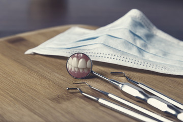 Dentists tools and mask with reflection of teeth