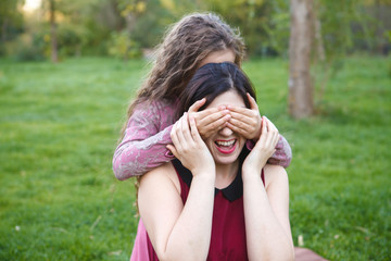 daughter mother closed her eyes with his hands, in the park