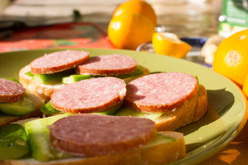 sandwich with sausage and a cucumber