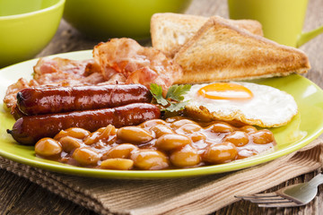 Full english breakfast with bacon, sausage, fried egg, baked bea