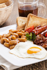 Full english breakfast with bacon, sausage, fried egg, baked bea