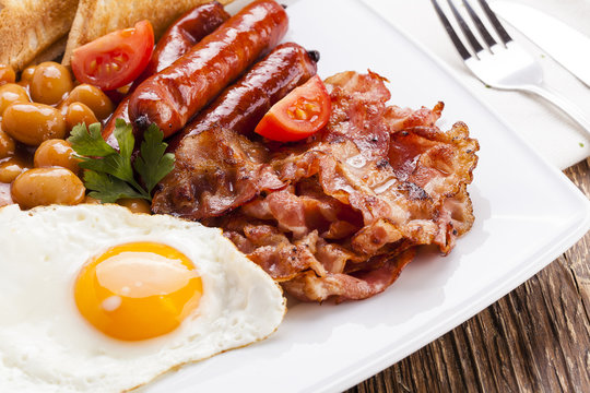 Full english breakfast with bacon, sausage, fried egg, baked bea