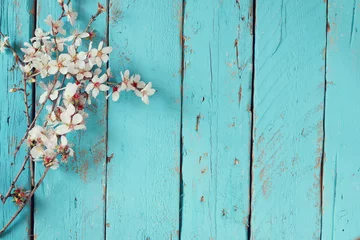 Fotobehang Bomen afbeelding van lente witte kersenbloesem boom op blauwe houten tafel