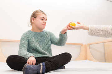 Disability a disabled child relaxing with a carer / Disability a disabled child relaxing together with a special needs carer with toys and music instruments