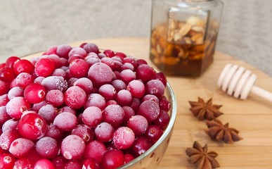 cranberries, honey, anise on wooden table.