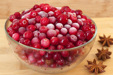 Ice cranberries with anice on wooden table.