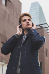 Young man listening to music in the city streets