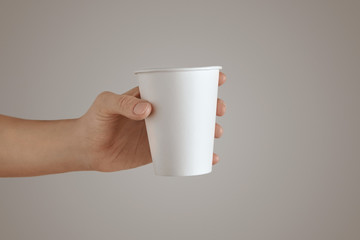 Woman hand holds paper glass isolated white