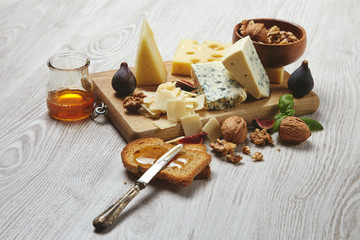Set four cheeses served with figs and nuts side view