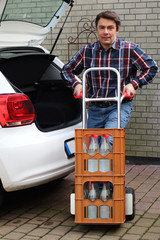 Mann hebt Getränkekiste rückenschonend