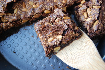 homemade chocolate walnuts and pine nuts brownie with coconut sprinkles in the pan