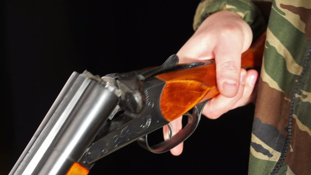 Close up of loading and unloading hunting rifle over black background