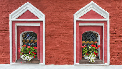 brick building decorated with flowers geraniums and petunias