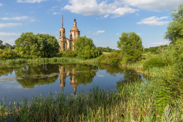 Summer landscape with an old ruined church on the bank of the pond. Church of the Ascension in the village Skorodnoye in the Lipetsk region 