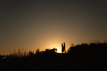 Fototapeta premium lovers at sunset are facing each other. Love. Relations. Tenderness