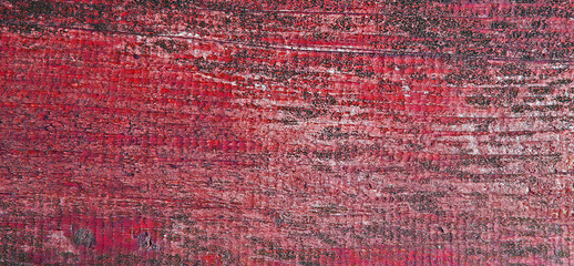 Red background texture of weathered, faded paint on wood. 