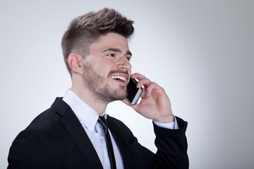 Businessmann telefoniert mit Handy und lächelt Porträt