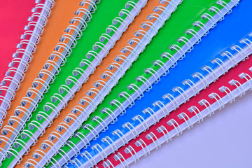Multicolored exercise books over the white floor